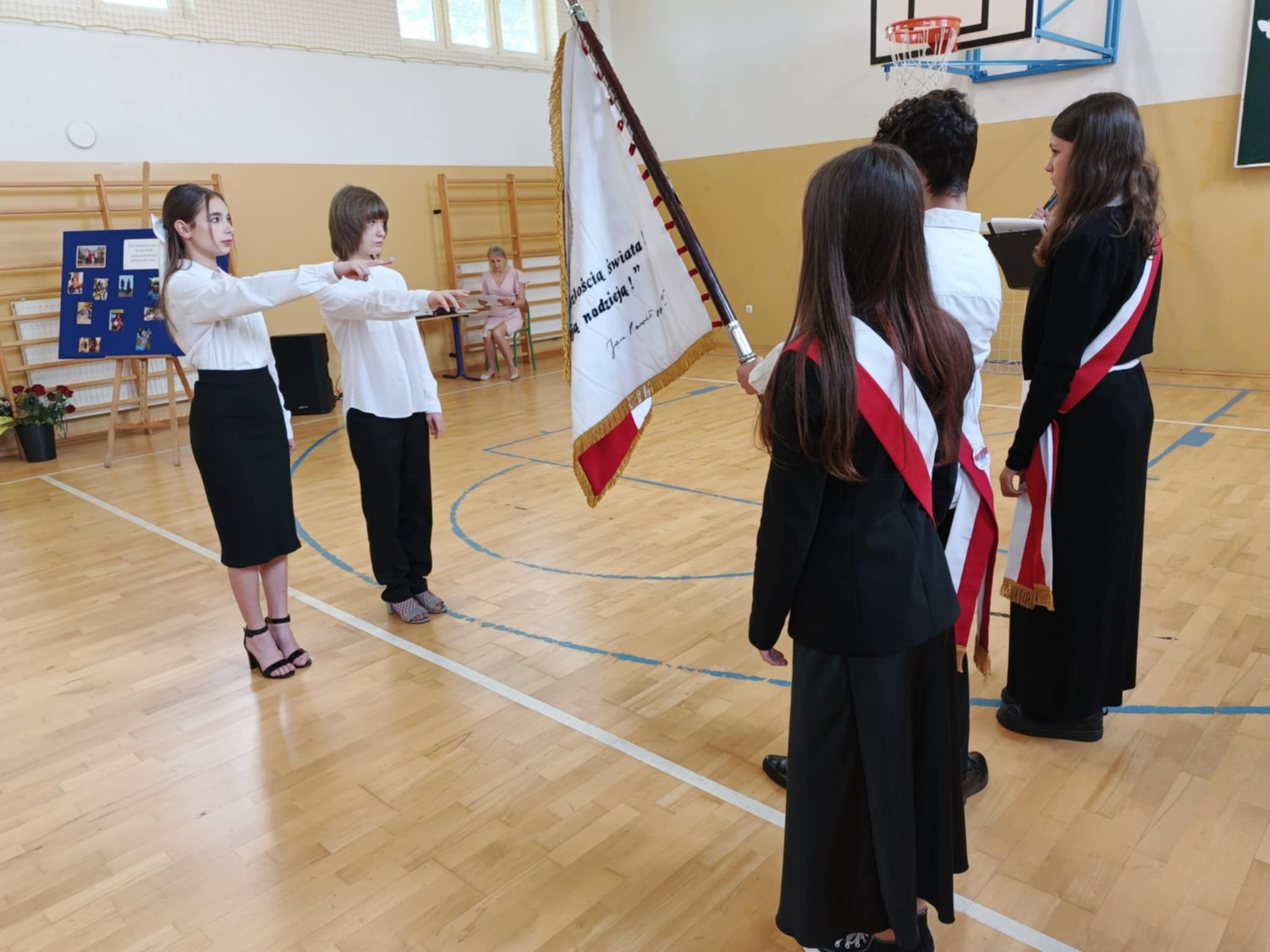 Uczniowie klasy ósmej składają ślubowanie przed pocztem sztandarowym szkoły.